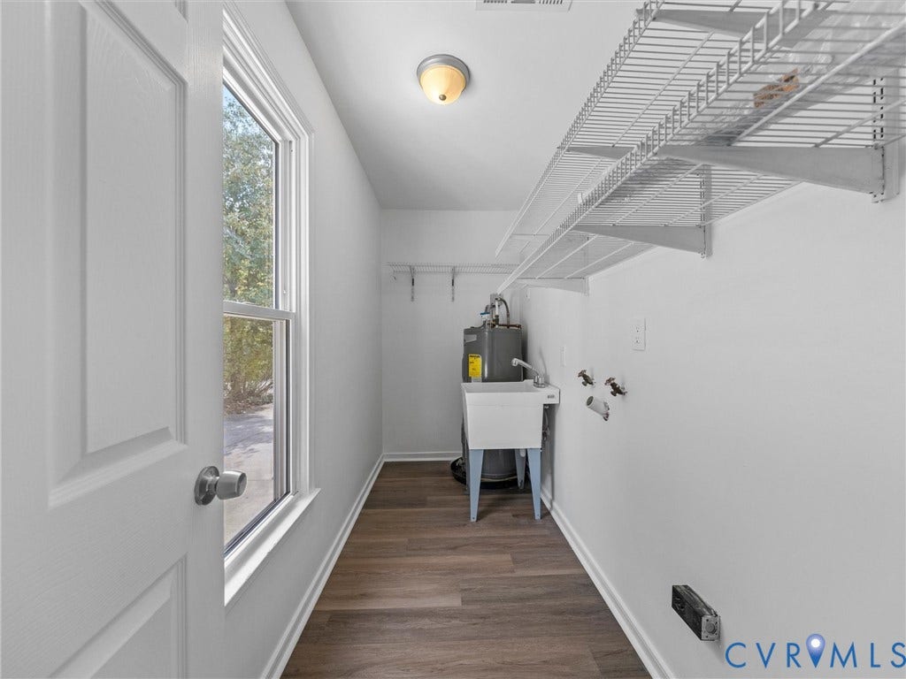 5504 Chanson Road, Salem Woods, North Chesterfield, VA 23237 Utility room featuring wood-finish flooring, a wall-mounted wire shelving system, a freestanding utility sink, and a flush-mount ceiling light fixture