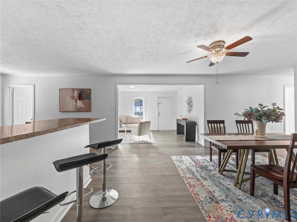 5504 Chanson Road, Salem Woods, North Chesterfield, VA 23237 Open concept interior featuring wood-finish flooring, breakfast bar with stone-surfaced countertop, and ceiling fan with integrated lighting