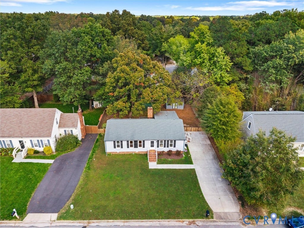 5504 Chanson Road, Salem Woods, North Chesterfield, VA 23237 Single-story residence featuring a shingled roof, exterior brick chimney, concrete driveway, and mature landscaping on a tree-lined lot
