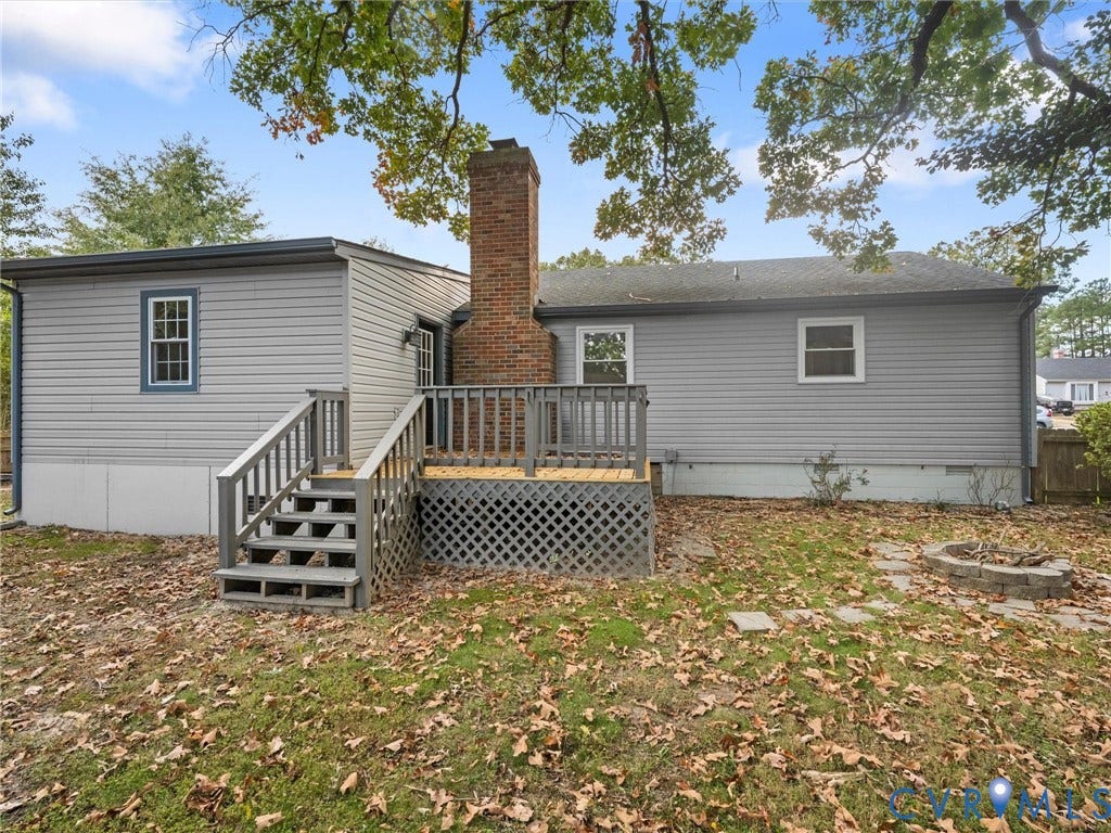 5504 Chanson Road, Salem Woods, North Chesterfield, VA 23237 Exterior siding, central masonry chimney, raised wooden deck with lattice skirting, and stone fire pit