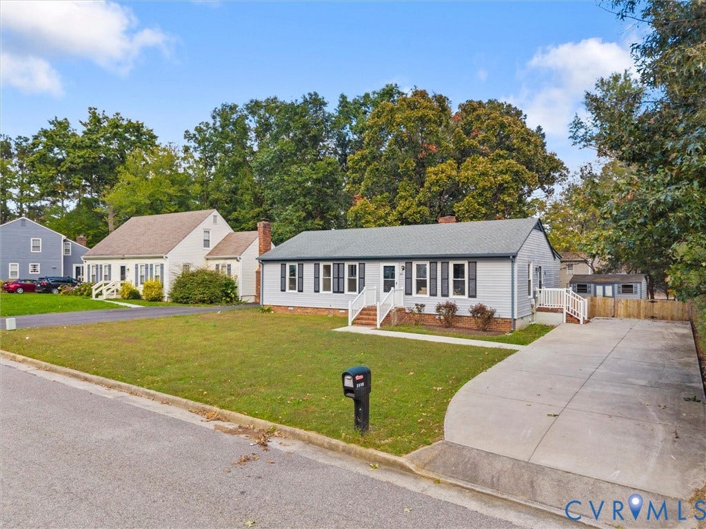 5504 Chanson Road, Salem Woods, North Chesterfield, VA 23237 Single-story residence featuring horizontal lap siding, a shingled roof, dark louvered shutters, an attached concrete driveway, and a fenced exterior storage structure