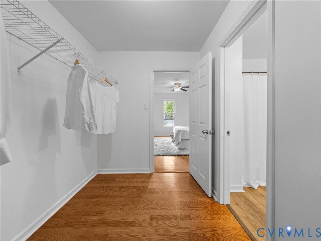 5504 Chanson Road, Salem Woods, North Chesterfield, VA 23237 Walk-in closet featuring wood-finish flooring and wire shelving, with a six-panel door opening into a tiled floor bathroom