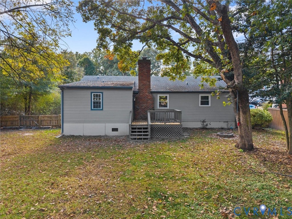 5504 Chanson Road, Salem Woods, North Chesterfield, VA 23237 Exterior featuring horizontal siding, a central brick chimney, a wood deck with lattice skirting, and mature trees on a level lot