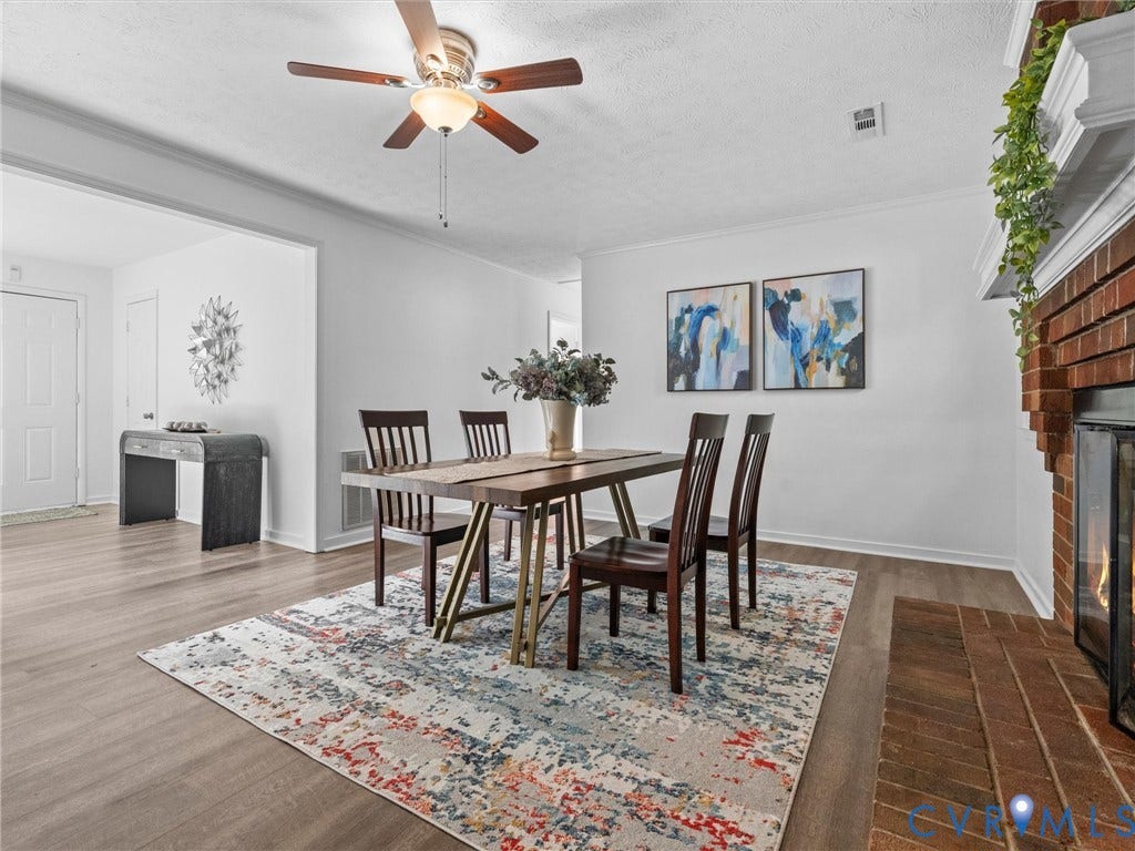 5504 Chanson Road, Salem Woods, North Chesterfield, VA 23237 Wood-finish flooring, red brick fireplace with a white mantel, and ceiling fan with integrated lighting