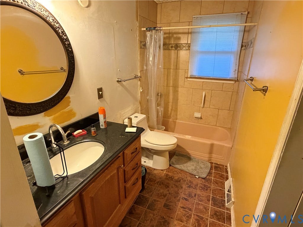 1513 West Lane, Petersburg, VA 23803 Bathroom featuring a wooden vanity with a dark countertop, integrated basin, tub and shower combination with tile surround, and tile flooring