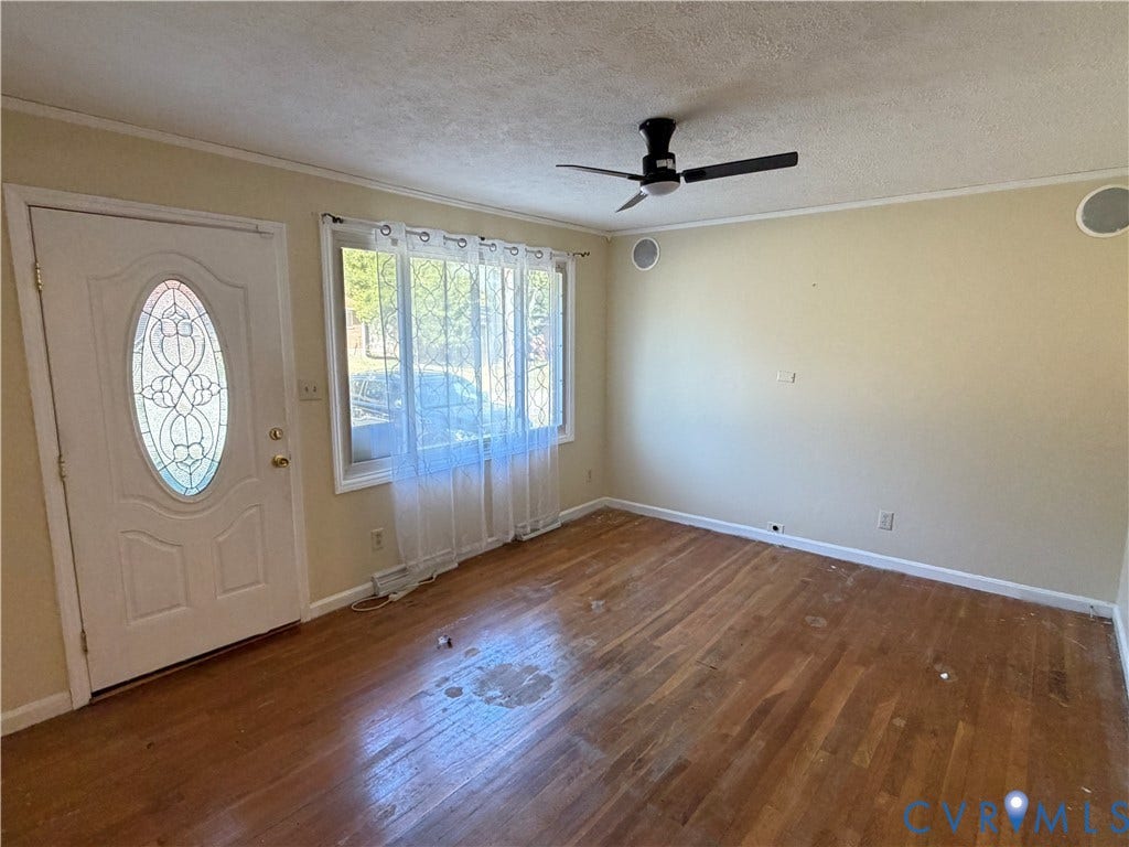 1513 West Lane, Petersburg, VA 23803 Wood-finish flooring, white exterior door with oval glass inset, large multi-pane window, and ceiling fan with integrated lighting