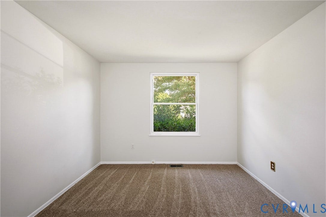 Neutral-toned room featuring neutral wall-to-wall carpeting and a single-hung window