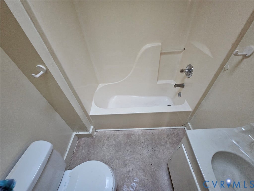 3503 Lawson Street, Richmond, VA 23224 Full bathroom featuring a molded composite tub and shower surround, a standard-height toilet, and a vanity with an integrated basin