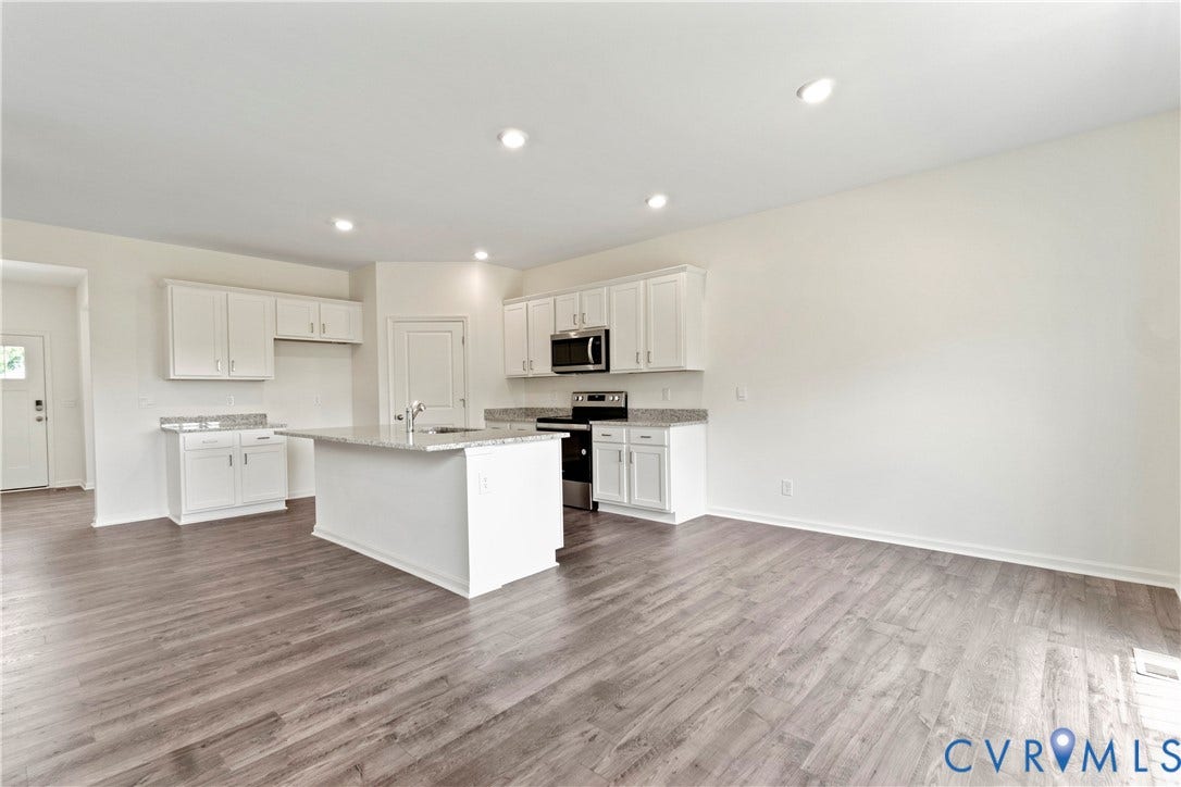 11231 Chappell Creek Circle, Chappell Creek, North Prince George, VA 23860 Open-concept kitchen featuring an island with a stainless steel sink, light-toned cabinetry, granite countertops, and wood-finish flooring