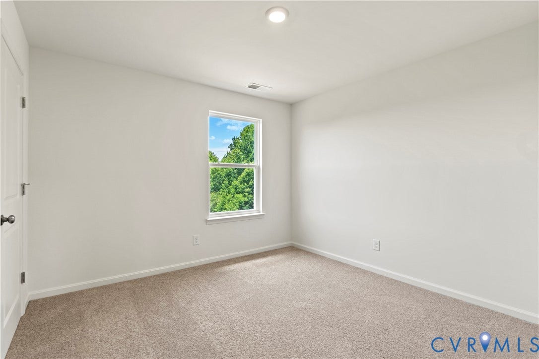 11231 Chappell Creek Circle, Chappell Creek, North Prince George, VA 23860 Bright interior space featuring neutral wall tones, carpet flooring, a window with a green tree backdrop, a recessed ceiling light, and a white paneled door