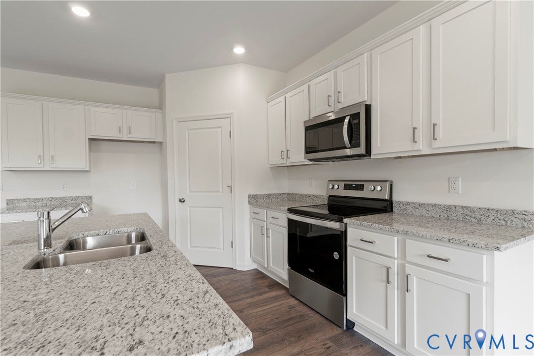 11231 Chappell Creek Circle, Chappell Creek, North Prince George, VA 23860 Kitchen featuring a double basin stainless steel sink, chrome faucet, white cabinetry, granite countertops, and stainless steel appliances