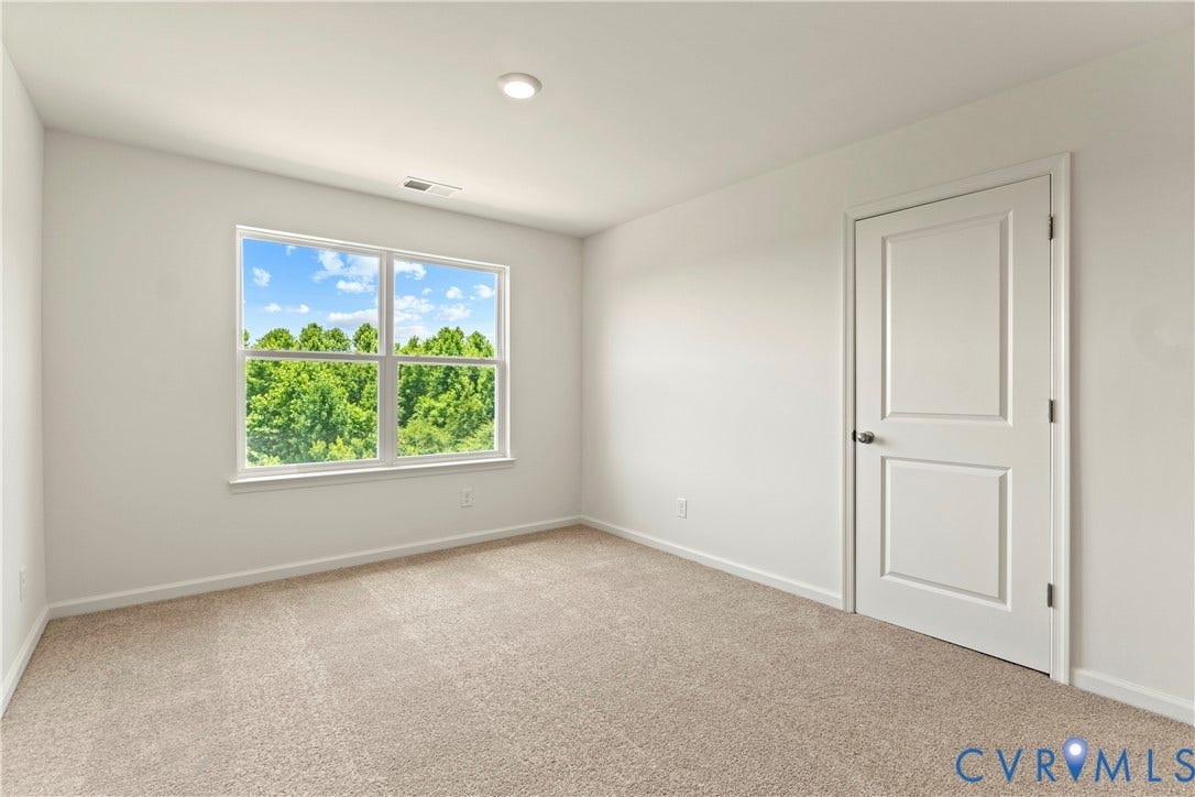 11231 Chappell Creek Circle, Chappell Creek, North Prince George, VA 23860 Spacious room featuring neutral carpeting, a large multipane window, and a two-panel door with brushed nickel hardware