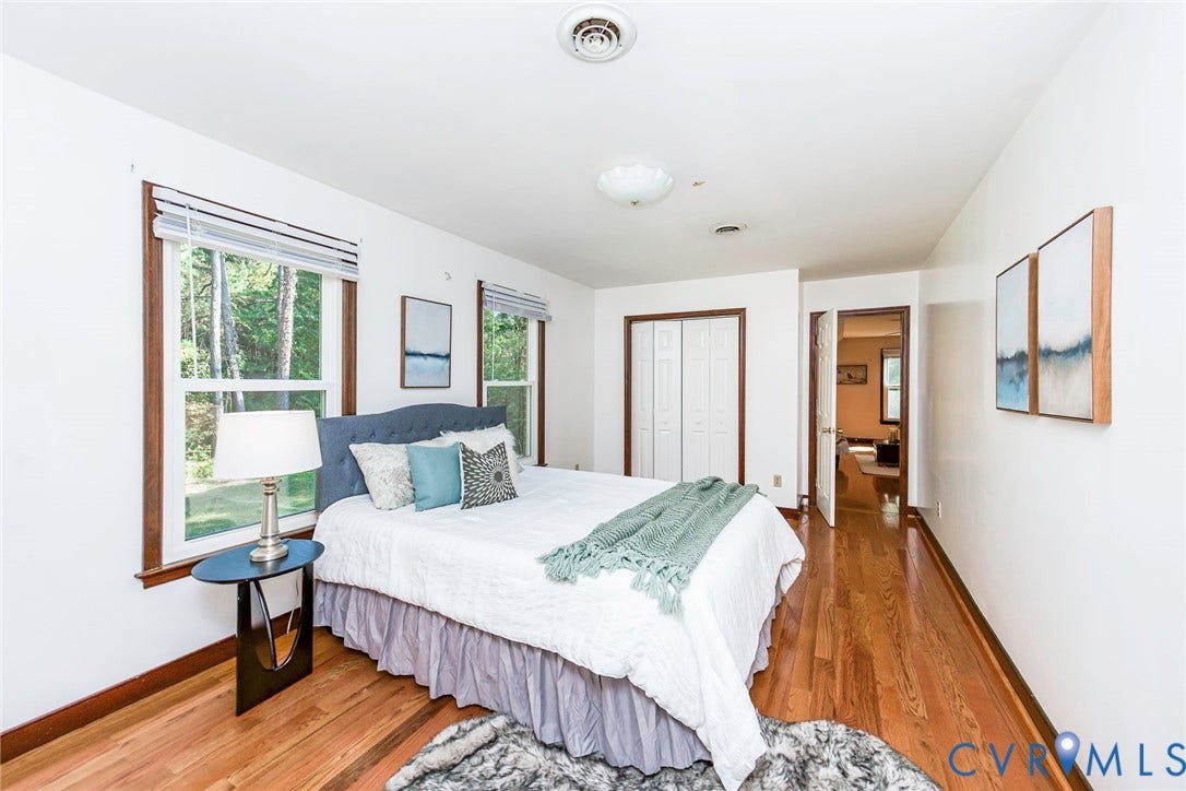 4124 Cogbill Road, Ampthill, VA 23234 Bedroom featuring wood-finish flooring, dual windows with wood trim, and bi-fold closet doors