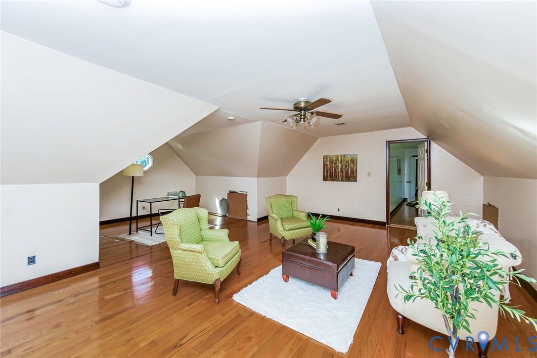 4124 Cogbill Road, Ampthill, VA 23234 Spacious room featuring wood-finish flooring, vaulted ceilings with angled architectural lines, and a ceiling-mounted light fixture