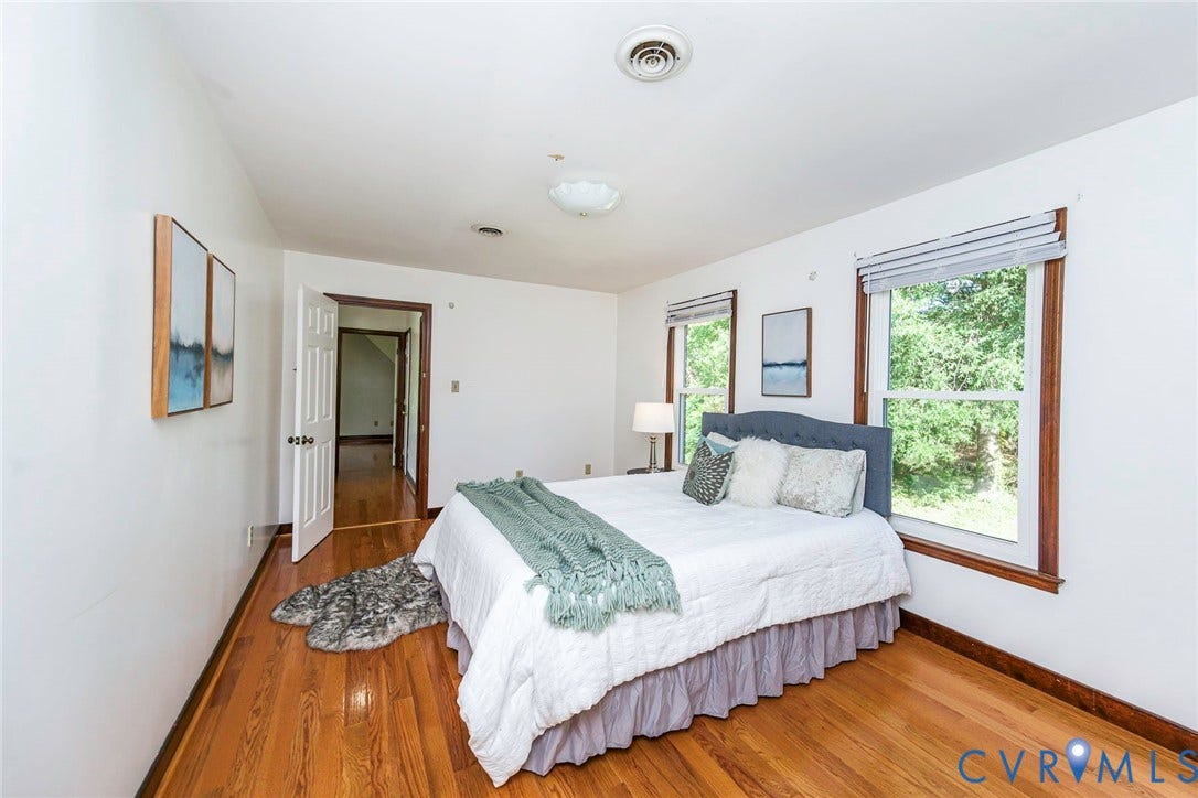 4124 Cogbill Road, Ampthill, VA 23234 Bedroom featuring wood-finish flooring, two windows with wood casing, and ceiling-mounted lighting