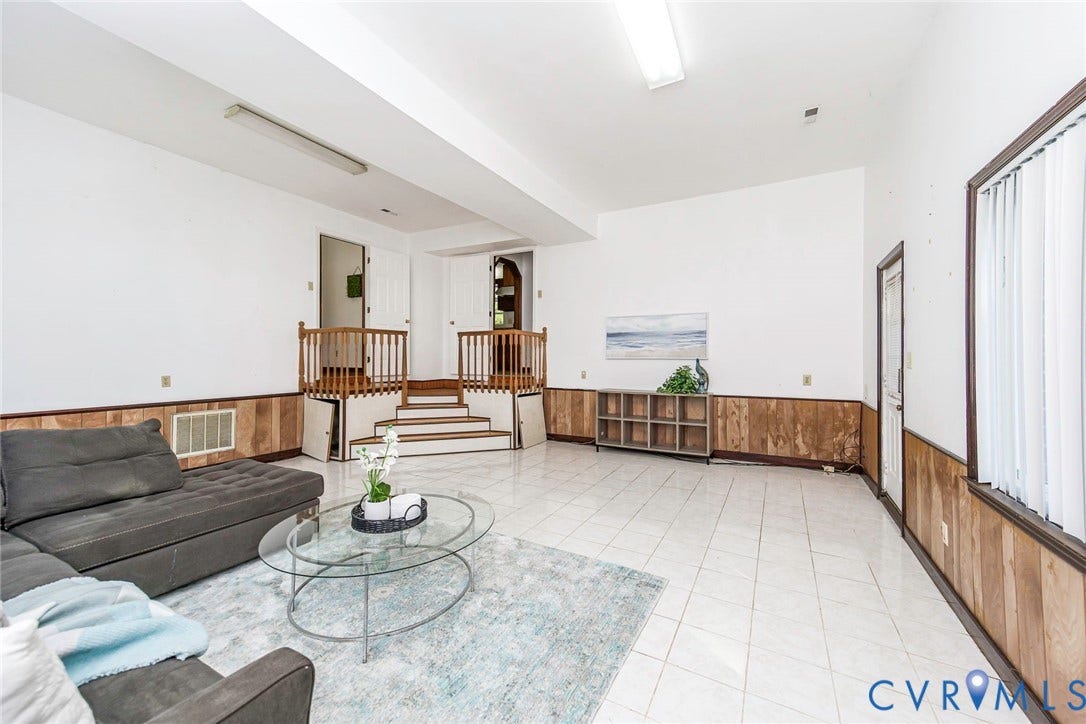 4124 Cogbill Road, Ampthill, VA 23234 Spacious interior featuring light-colored tile flooring, wood panel wainscoting, and a multi-level staircase with wooden railing