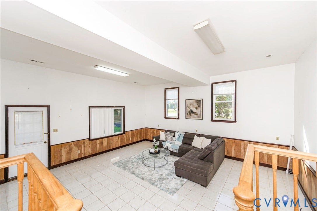 4124 Cogbill Road, Ampthill, VA 23234 Interior space featuring ceramic tile flooring, wood-panel wainscoting, three windows, and a wood railing