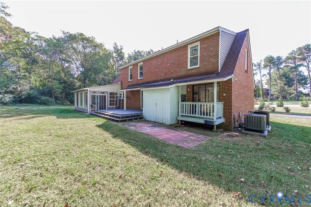 4124 Cogbill Road, Ampthill, VA 23234 Brick exterior construction featuring a multi-level deck, enclosed sunroom, elevated rear porch, and stone-paved patio area