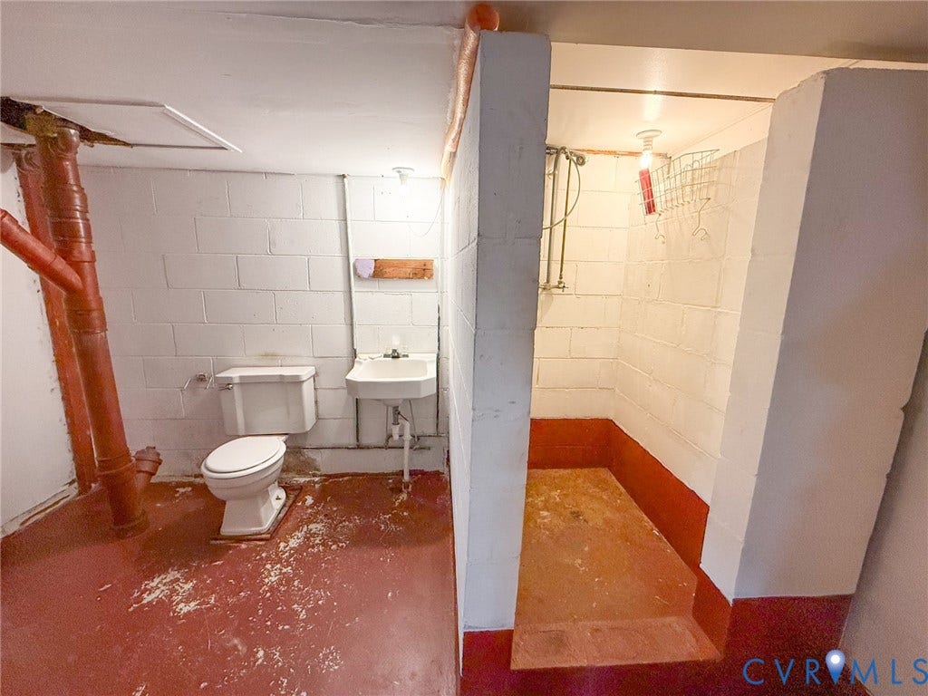 109 Rock Castle Avenue, Crewe, VA 23930 Utility area featuring concrete block walls, a pedestal sink, porcelain toilet, and a tiled shower stall