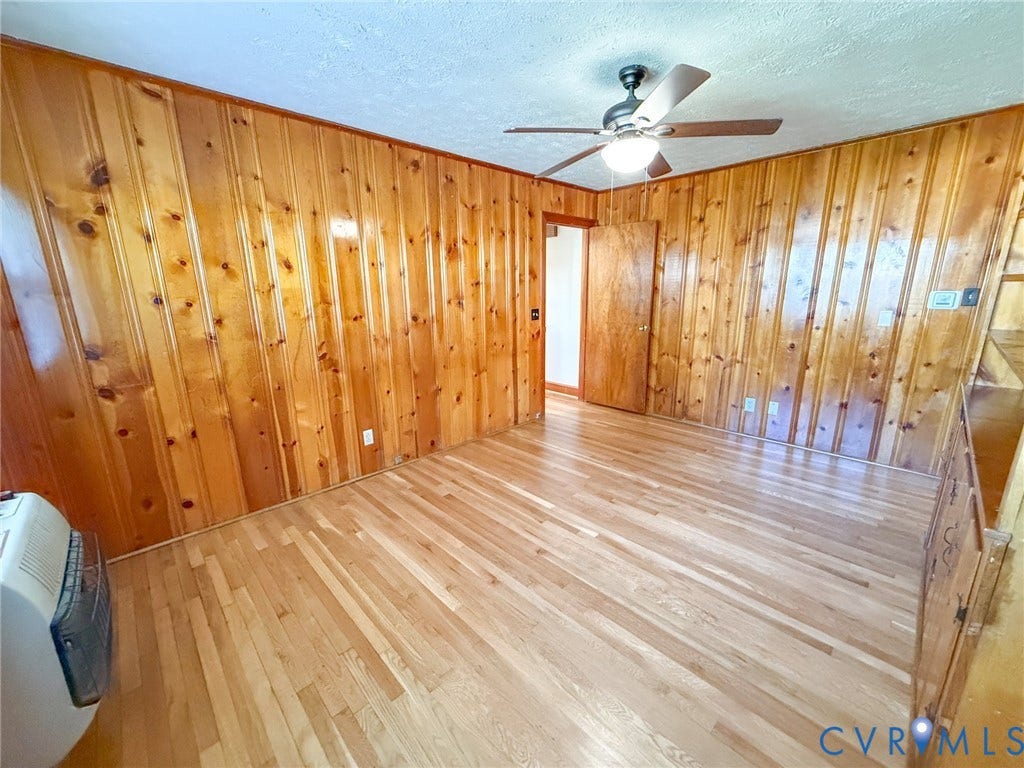109 Rock Castle Avenue, Crewe, VA 23930 Interior space featuring vertical wood-paneled walls, wood-finish flooring, and a ceiling fan with integrated lighting