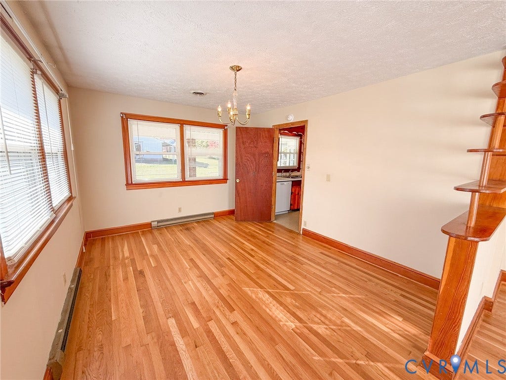 109 Rock Castle Avenue, Crewe, VA 23930 Hardwood flooring, multi-pane windows with wood trim, built-in wooden shelving, and a hanging chandelier