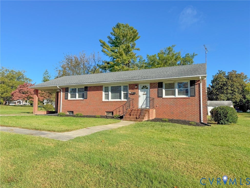 109 Rock Castle Avenue, Crewe, VA 23930 Single-story brick exterior featuring a covered side porch, asphalt shingle roof, black window shutters, and metal hand railings at the entry