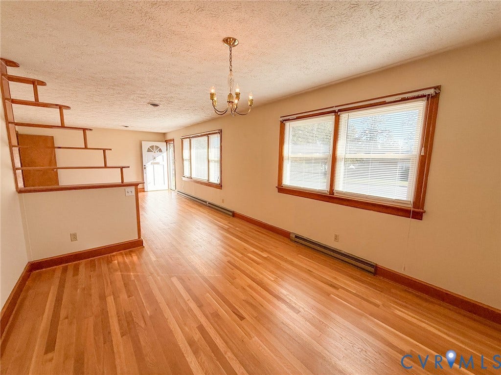109 Rock Castle Avenue, Crewe, VA 23930 Interior space featuring wood-finish flooring, wood-trimmed windows, a multi-tiered open wood staircase railing, and a traditional multi-arm chandelier