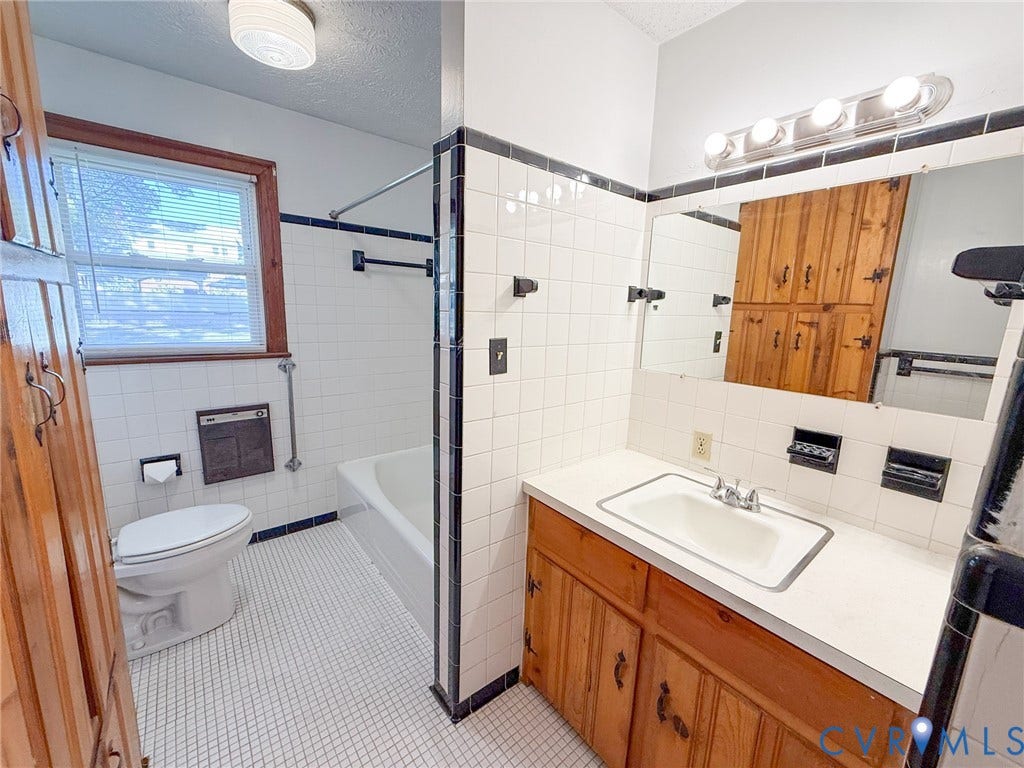 109 Rock Castle Avenue, Crewe, VA 23930 Bathroom featuring a vanity with integrated sink and countertop, full-height tile wall surround, built-in natural wood cabinetry, and a combination tub and shower