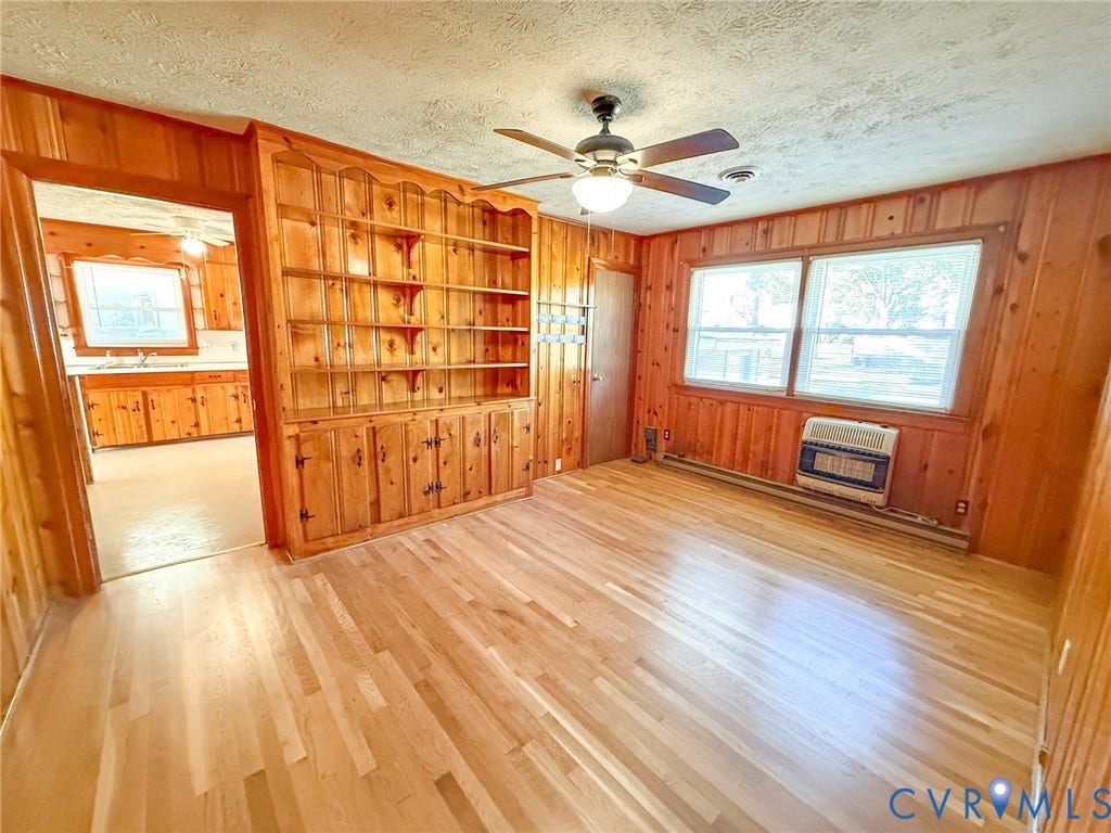 109 Rock Castle Avenue, Crewe, VA 23930 Wood-panelled interior featuring wood-finish flooring, built-in wooden shelving, a ceiling fan with integrated light fixture, and large multi-pane windows