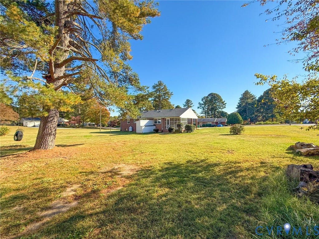 109 Rock Castle Avenue, Crewe, VA 23930 Expansive grassy lot featuring a brick-exterior residence, a covered patio, and large mature trees