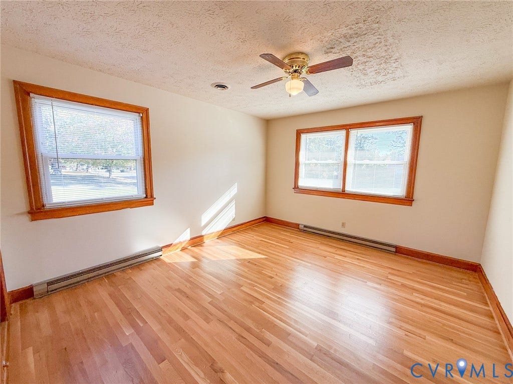 109 Rock Castle Avenue, Crewe, VA 23930 Interior space featuring wood-finish flooring, natural wood window trim, and a ceiling-mounted light fixture with a multi-blade fan
