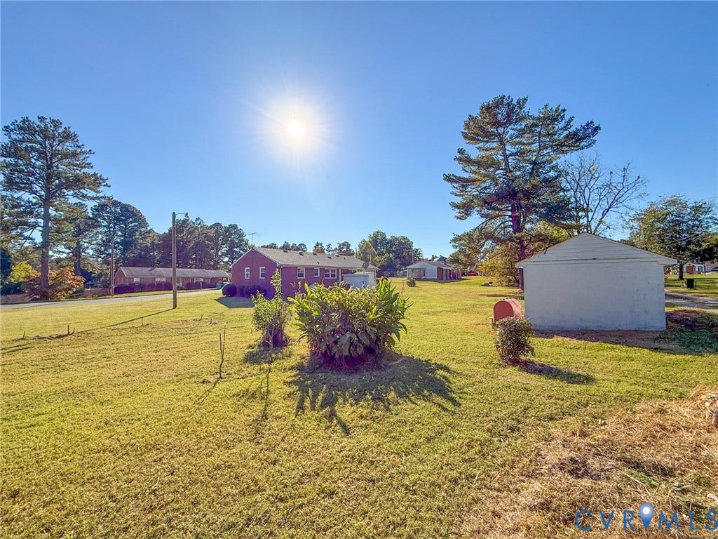 109 Rock Castle Avenue, Crewe, VA 23930 Expansive lot featuring a brick-exterior residence, a detached storage structure, and mature trees