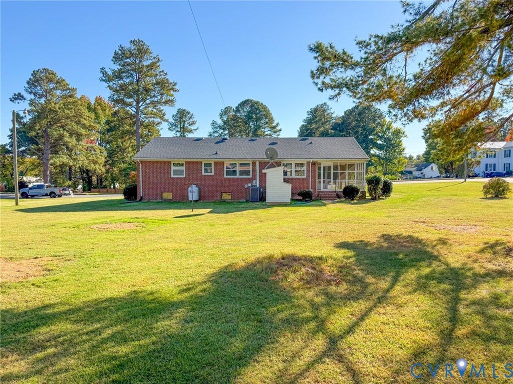 109 Rock Castle Avenue, Crewe, VA 23930 Brick exterior residence featuring an expansive lawn, asphalt shingle roof, and a screened-in porch