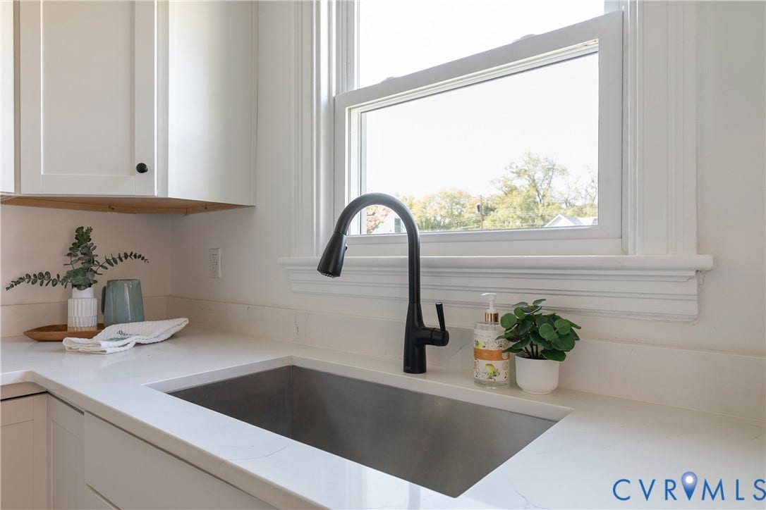 24 N Elm Avenue, Henrico, VA 23075 Undermount stainless steel kitchen sink featuring a matte black high-arc pull-down faucet, white stone-composite countertops, and white shaker-style cabinetry