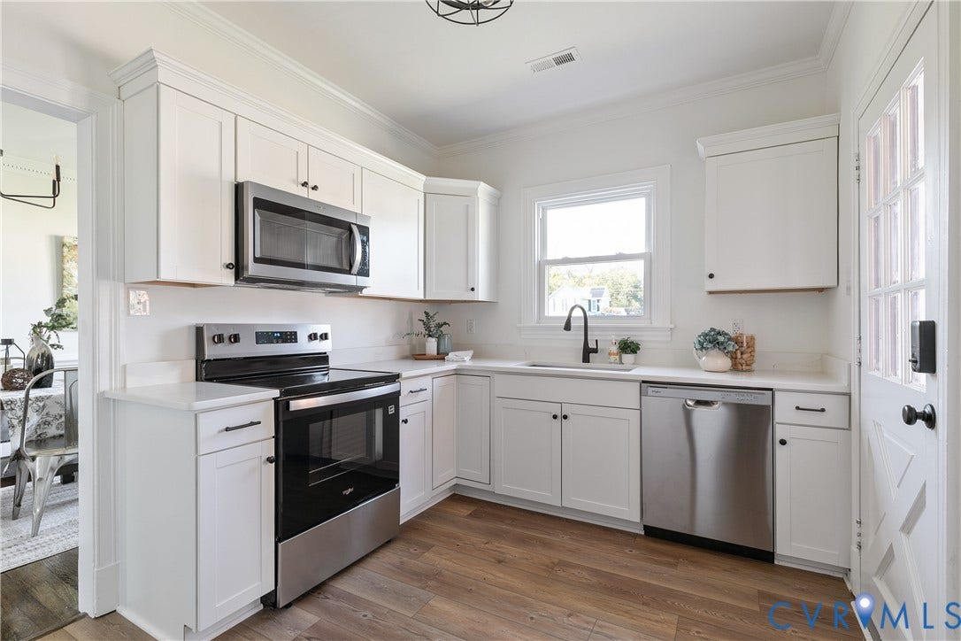 24 N Elm Avenue, Henrico, VA 23075 Kitchen featuring white shaker-style cabinetry, solid-surface countertops, stainless steel appliances, matte black plumbing fixtures, and wood-finish flooring