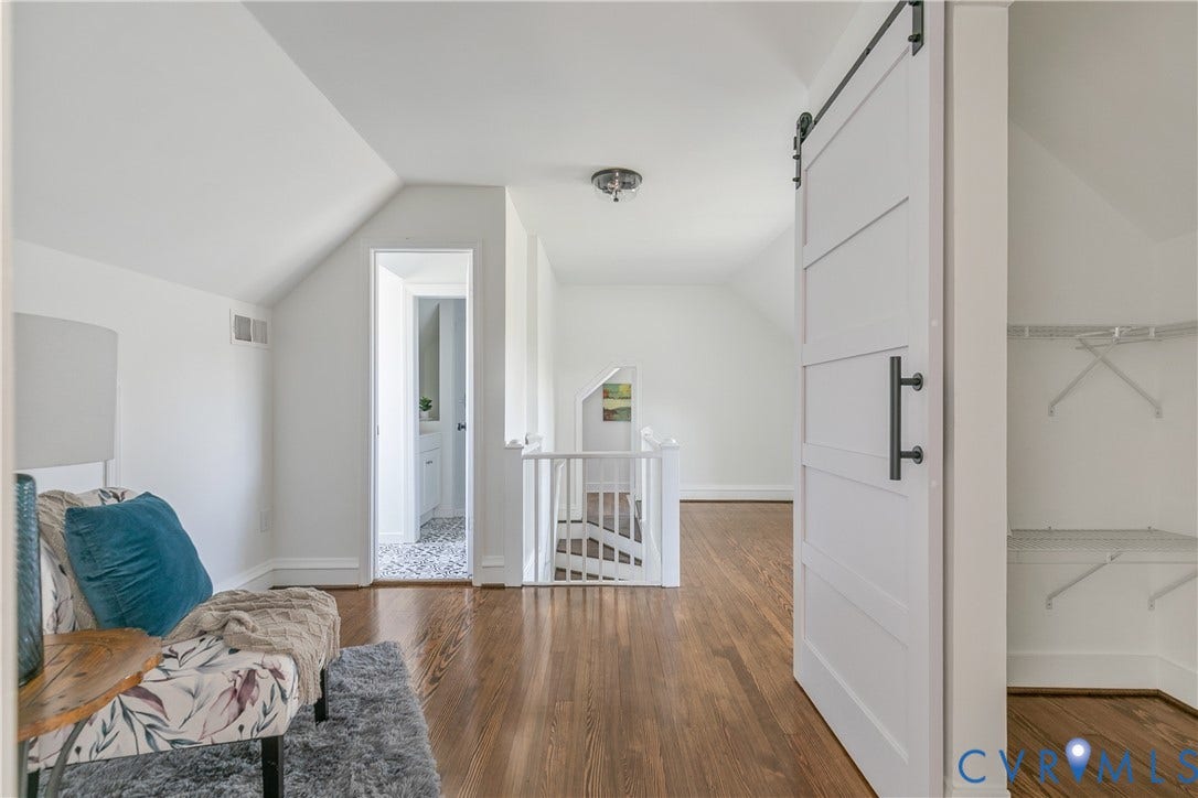 24 N Elm Avenue, Henrico, VA 23075 Interior space featuring wood-finish flooring, a white sliding barn door with matte black hardware, and an attached white railing system