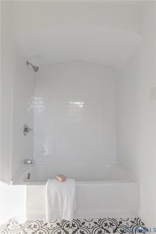 24 N Elm Avenue, Henrico, VA 23075 Alcove bathtub featuring white subway tile surround, arched ceiling detail, polished chrome plumbing fixtures, and patterned tile flooring