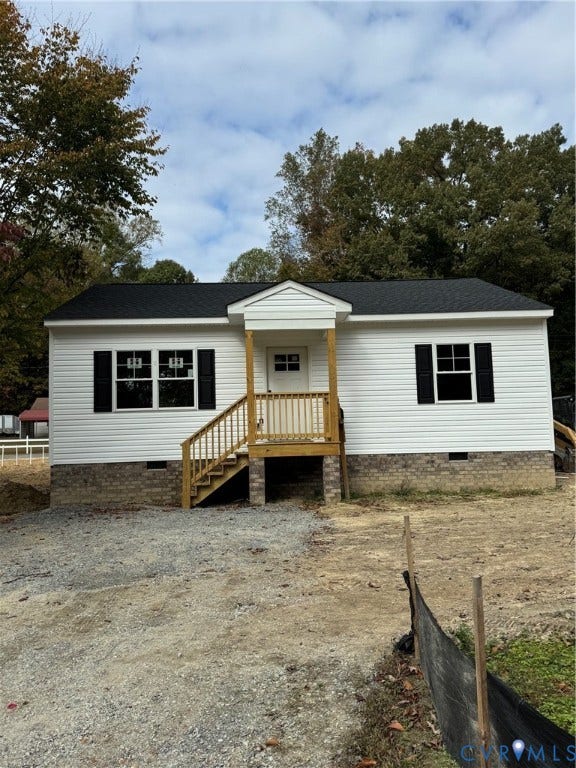 6012 Lakeside Drive, Woodhaven Shores, Quinton, VA 23141 Single-story exterior featuring white vinyl siding, dark shutters, a brick foundation, a black shingled roof, and a wood-post covered entryway