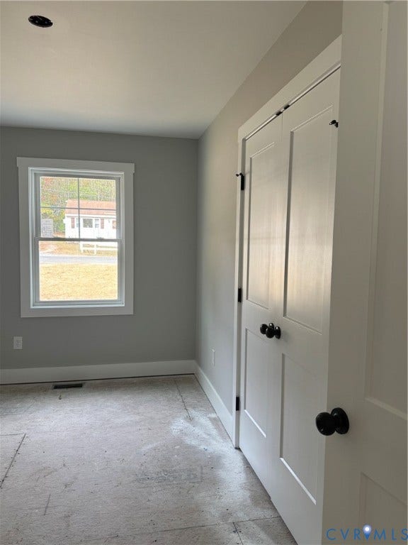 6012 Lakeside Drive, Woodhaven Shores, Quinton, VA 23141 Neutral paint tones, double-panel closet doors with matte black hardware, and a window with muntin detailing