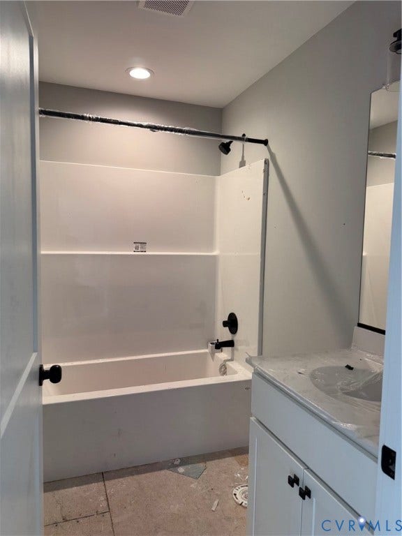 Bathroom featuring a white vanity with a neutral stone-finish countertop, white acrylic tub-shower surround, matte black plumbing fixtures, and recessed lighting
