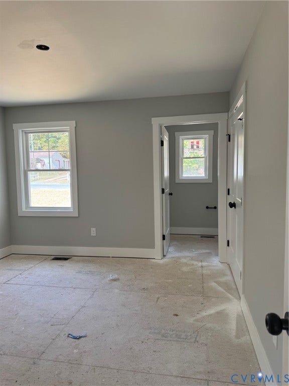 Interior featuring neutral wall paint, white wood-trim casing, double-pane grid windows, and matte black hardware