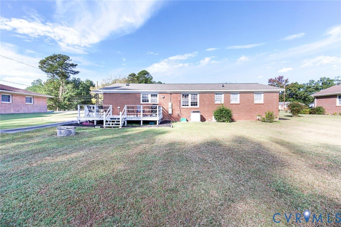 700 Lakeside Drive, Emporia, Emporia, VA 23847 Brick exterior residence featuring a raised wood deck, multi-pane windows, and an expansive lawn