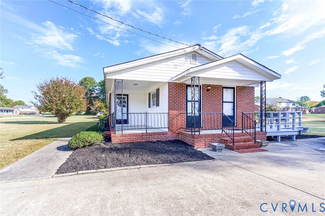 700 Lakeside Drive, Emporia, Emporia, VA 23847 Single-story exterior featuring a brick facade, white siding, covered porch with ornamental metal railings, and a concrete driveway