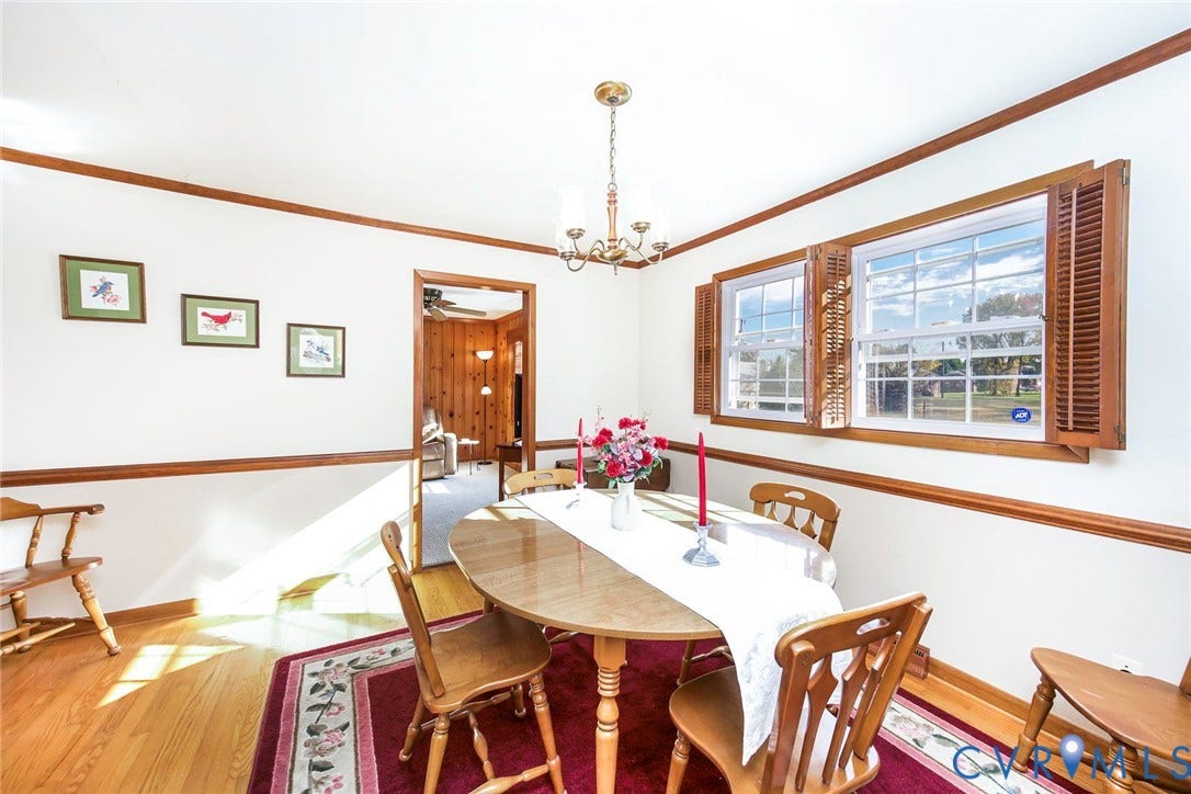 700 Lakeside Drive, Emporia, Emporia, VA 23847 Dining area featuring wood-finish flooring, wood chair rail molding, dual windows with wood-finish shutters, and a multi-arm chandelier