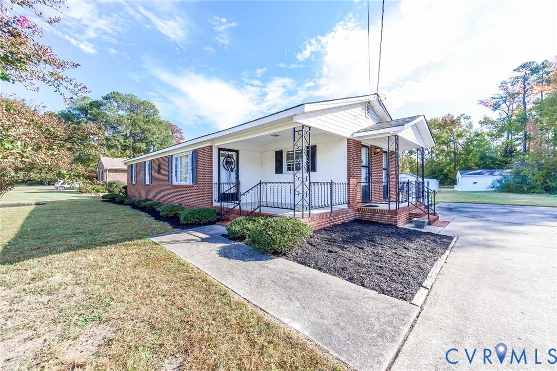 700 Lakeside Drive, Emporia, Emporia, VA 23847 Single-story brick and siding exterior featuring a covered front porch, decorative wrought-iron railings, and concrete driveway