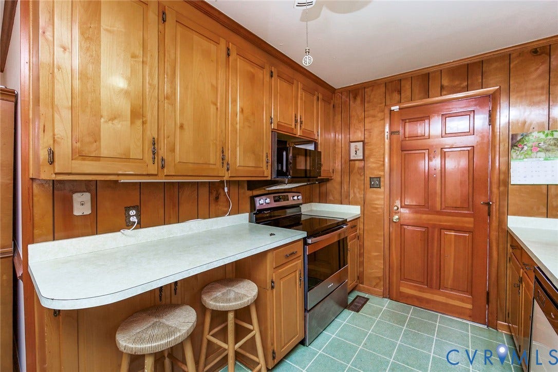 700 Lakeside Drive, Emporia, Emporia, VA 23847 Kitchen featuring wood cabinetry, natural wood-paneled walls, solid-surface countertops, and a stainless steel built-in range and microwave