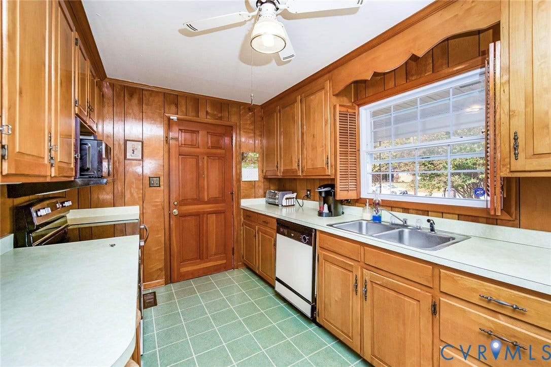 700 Lakeside Drive, Emporia, Emporia, VA 23847 Kitchen featuring wood cabinetry, natural wood-paneled walls, solid-surface countertops, dual-basin stainless steel sink, and ceramic tile flooring