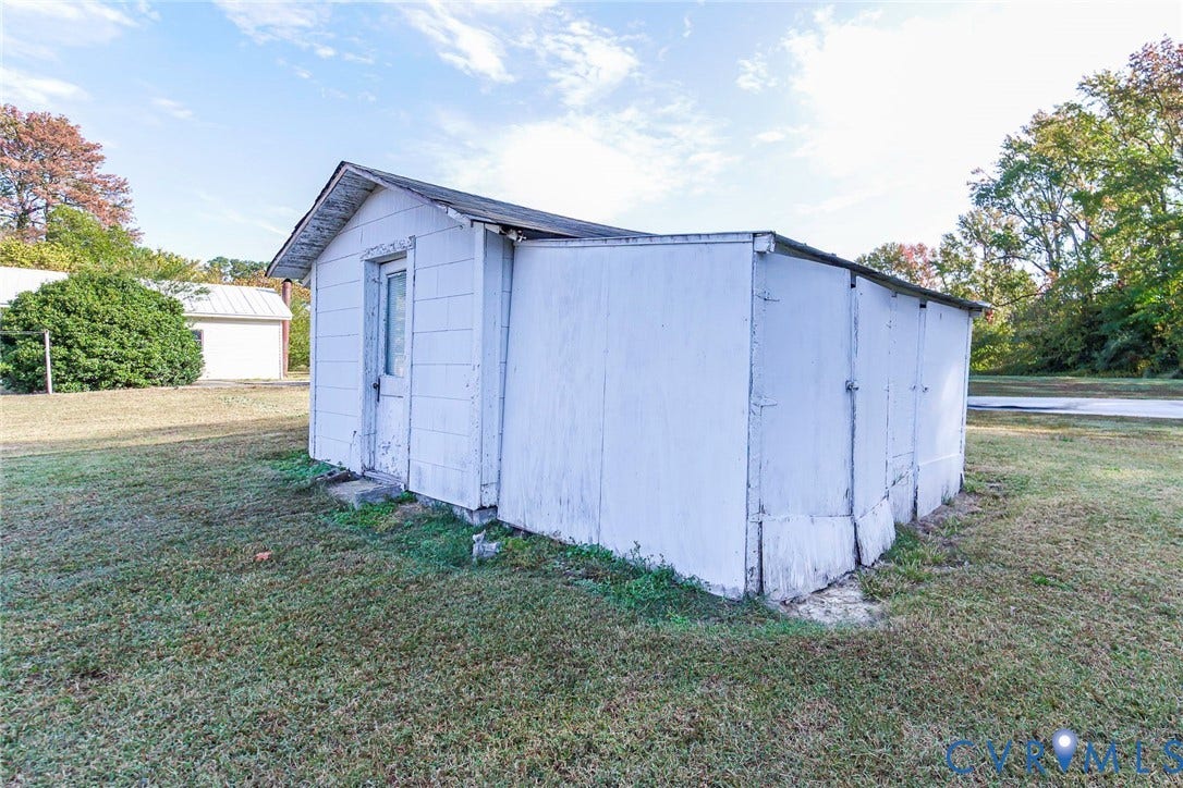700 Lakeside Drive, Emporia, Emporia, VA 23847 Detached outbuilding featuring white exterior siding, a gable roofline, and multiple access doors, situated on an expansive grass lot