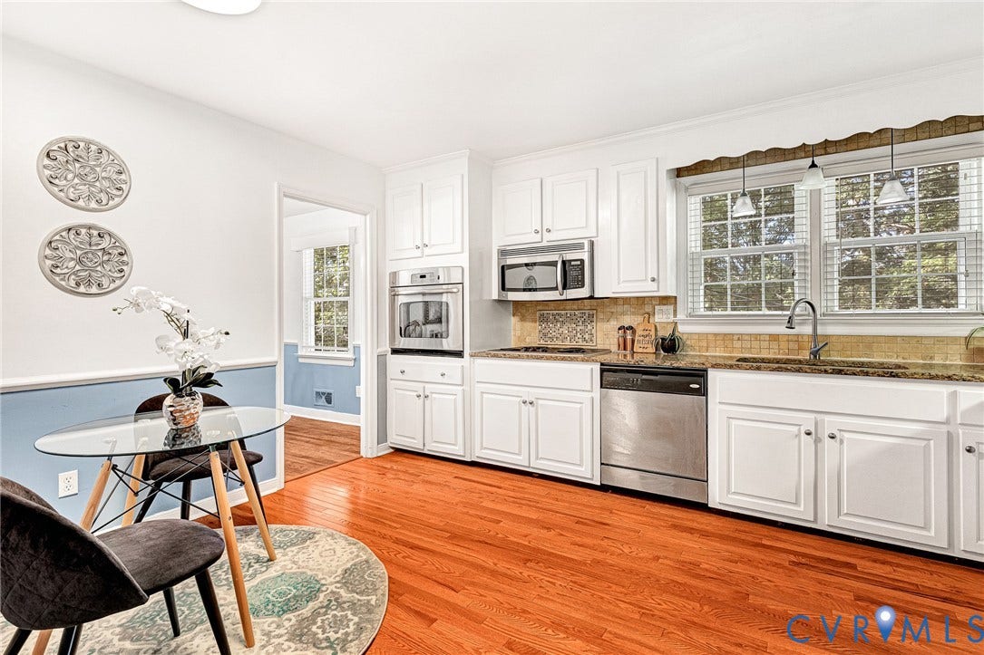 1526 Westshire Lane, Henrico, VA 23238 Kitchen featuring white cabinetry, wood-finish flooring, stainless steel appliances including a built-in wall oven and microwave, stone-surface countertops, and multi-pane windows