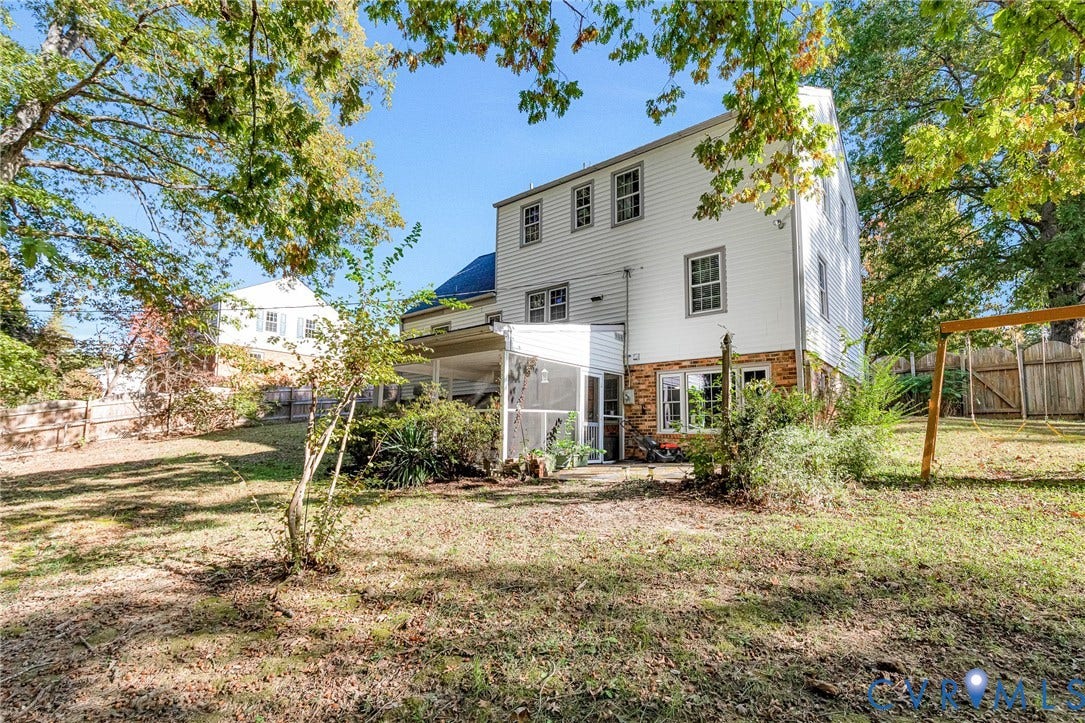 1526 Westshire Lane, Henrico, VA 23238 Multi-story residence featuring vinyl siding, brick foundation masonry, and a rear screened-in porch with wood framing, set upon a private lot with mature trees and perimeter wood fencing